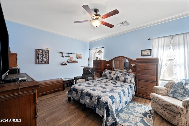 bedroom featuring ceiling fan, wood finished floors, visible vents, and crown molding