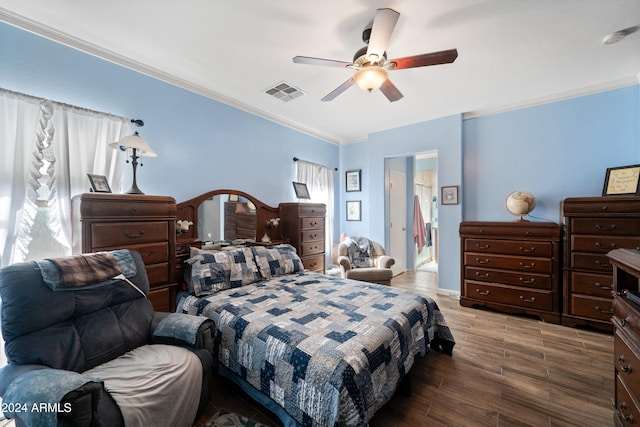 bedroom with a ceiling fan, visible vents, crown molding, and wood finished floors