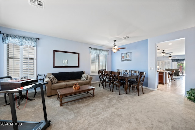 living room with a wealth of natural light, visible vents, and carpet flooring