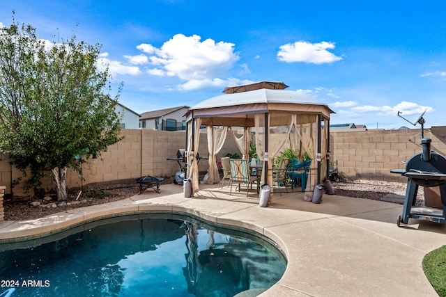 view of pool with a fenced backyard, grilling area, a patio, and a gazebo