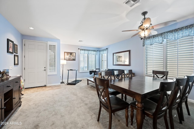 dining space featuring light carpet, baseboards, visible vents, and ceiling fan