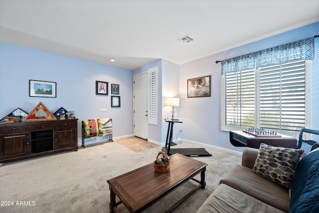 living room with light carpet, visible vents, and baseboards