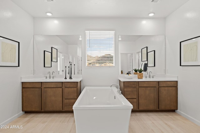 7333 W Buckhorn Trl, Peoria, AZ 85383 - full bathroom with two vanities, a freestanding bath, baseboards, and wood finished floors