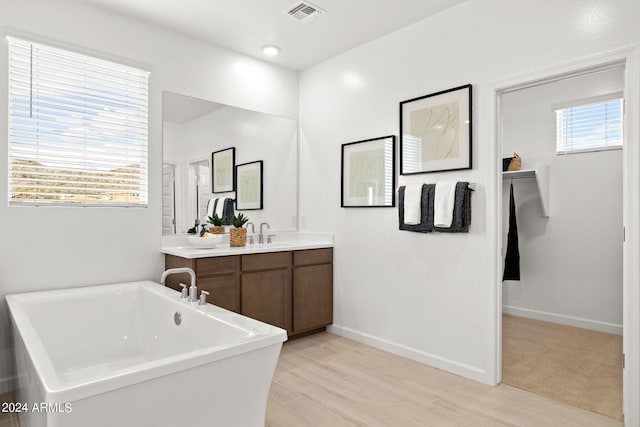 7333 W Buckhorn Trl, Peoria, AZ 85383 - bathroom with a freestanding tub, double vanity, wood finished floors, and baseboards