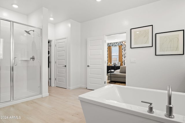 7333 W Buckhorn Trl, Peoria, AZ 85383 - full bath featuring a shower stall, a soaking tub, wood finished floors, connected bathroom, and baseboards
