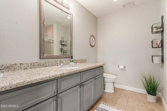 bathroom with toilet, vanity, and tile patterned floors