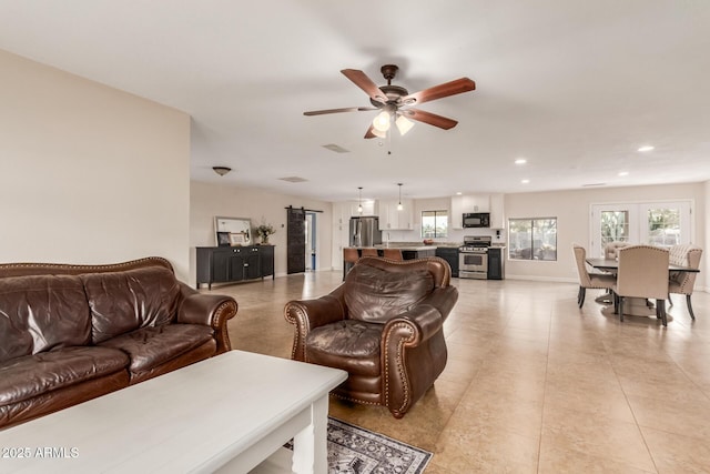 living room featuring ceiling fan and a wealth of natural light