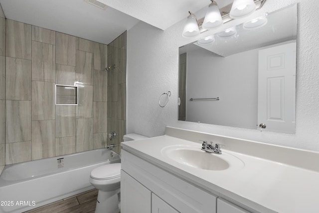 full bath with visible vents, a textured wall, toilet, wood finished floors, and  shower combination