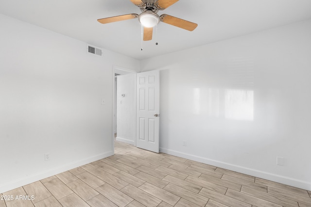 unfurnished room featuring a ceiling fan, wood finish floors, visible vents, and baseboards