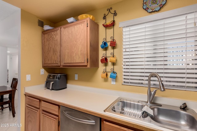 kitchen with stainless steel dishwasher, visible vents, light countertops, and a sink