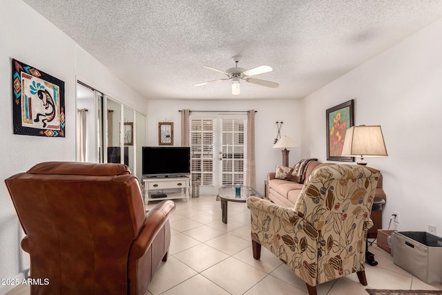 living room with light tile patterned floors, a textured ceiling, and a ceiling fan