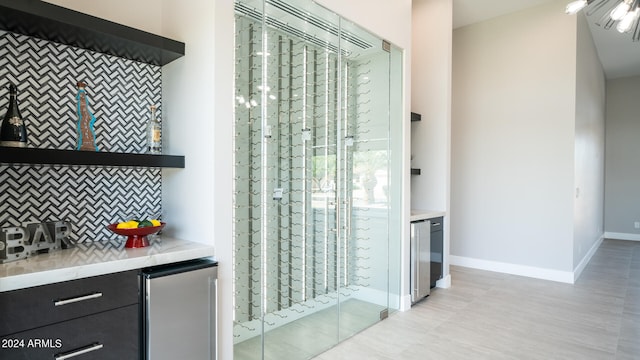 interior space with beverage cooler, stainless steel fridge, and decorative backsplash