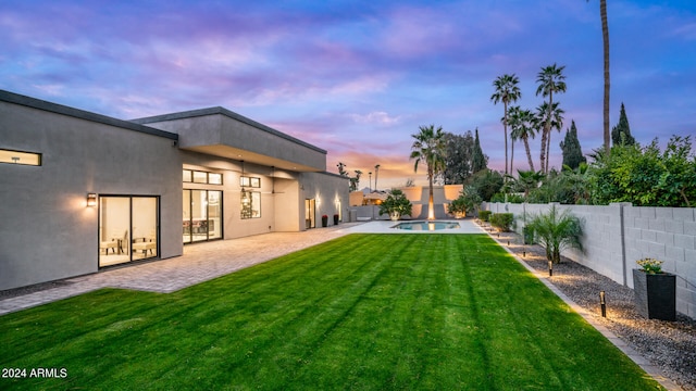 yard at dusk with a patio and a fenced in pool