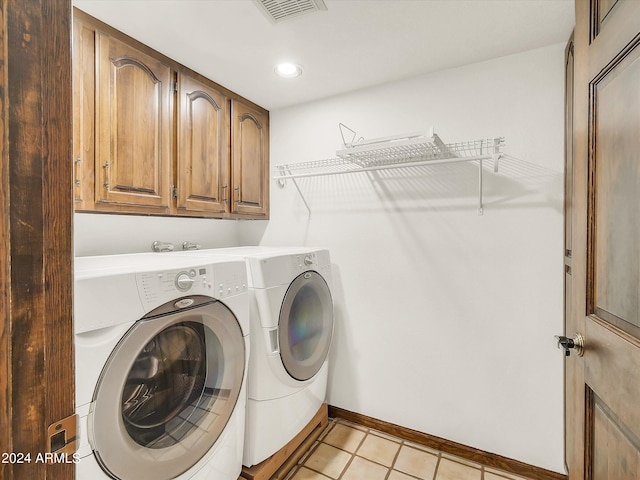 laundry area featuring cabinets, separate washer and dryer, and light tile floors