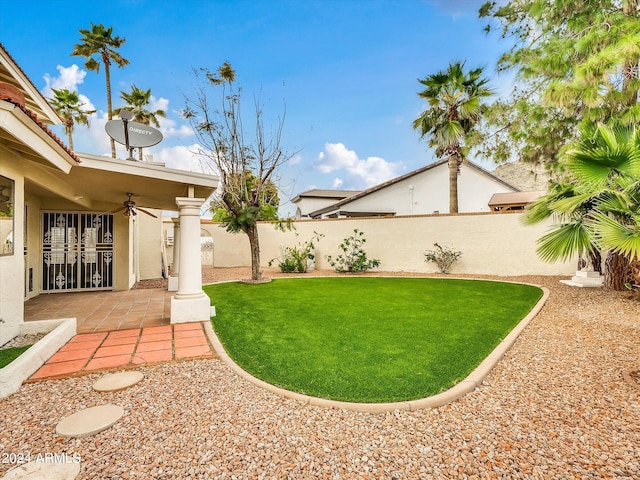 view of yard with ceiling fan and a patio area