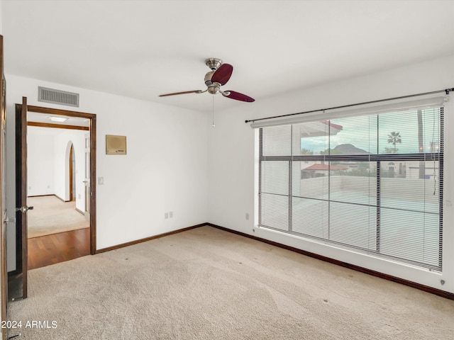 unfurnished room with light colored carpet and ceiling fan