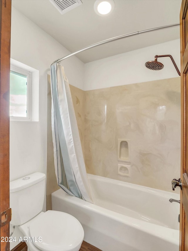 bathroom featuring toilet and shower / bathtub combination with curtain