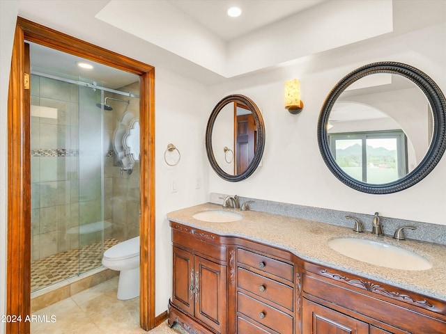 bathroom featuring toilet, oversized vanity, tile flooring, dual sinks, and an enclosed shower