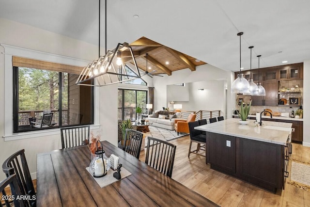 dining room featuring recessed lighting, vaulted ceiling with beams, and light wood-type flooring