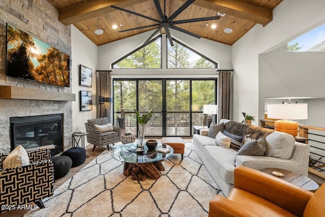 living area featuring beam ceiling, a fireplace, high vaulted ceiling, wooden ceiling, and wood finished floors