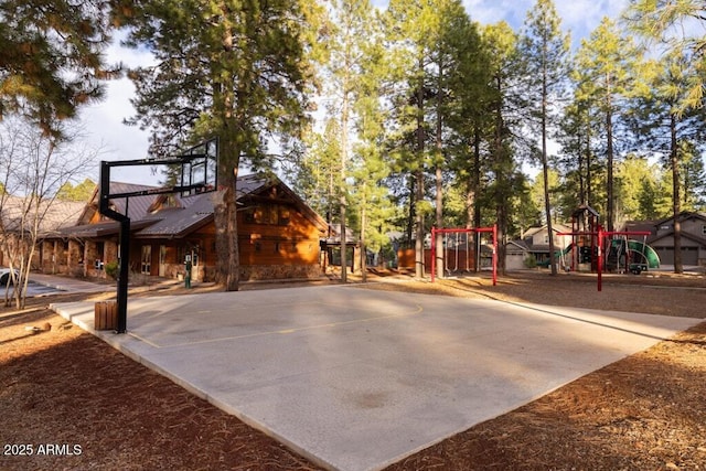view of basketball court featuring a playground