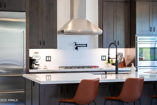 30600 N Pima Rd N Unit 81, Scottsdale, AZ 85266 - kitchen with stainless steel appliances, wall chimney exhaust hood, tasteful backsplash, and dark brown cabinets