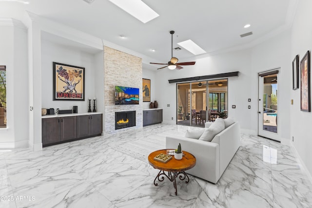 30600 N Pima Rd N Unit 81, Scottsdale, AZ 85266 - living room with a skylight, ornamental molding, light marble finish flooring, ceiling fan, and a fireplace