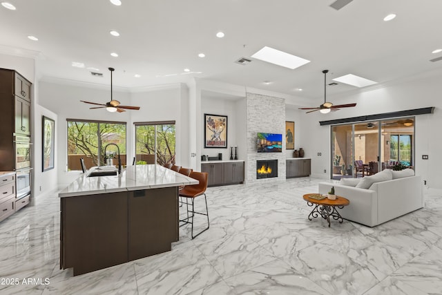 30600 N Pima Rd N Unit 81, Scottsdale, AZ 85266 - living room featuring crown molding, ceiling fan, a skylight, light marble finish flooring, and healthy amount of natural light