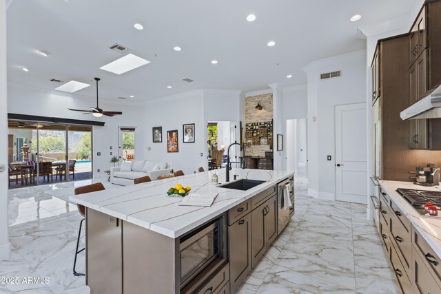 30600 N Pima Rd N Unit 81, Scottsdale, AZ 85266 - kitchen with a sink, stainless steel appliances, crown molding, open floor plan, and a center island with sink