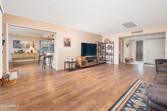 living room featuring wood-type flooring and a textured ceiling