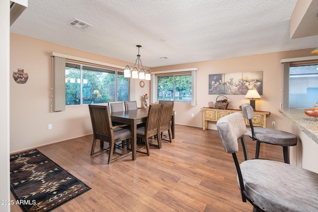 dining space featuring light hardwood / wood-style floors and a textured ceiling