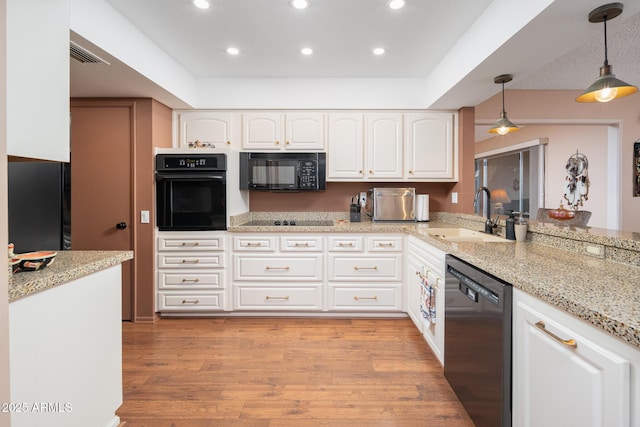 kitchen featuring light stone countertops, sink, black appliances, white cabinetry, and hanging light fixtures