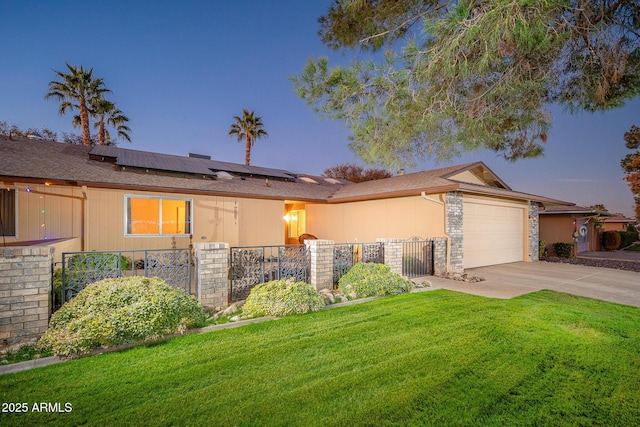 single story home with a lawn, solar panels, and a garage