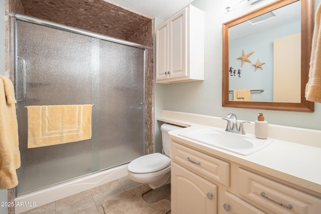 bathroom with toilet, vanity, tile patterned floors, and a shower with door