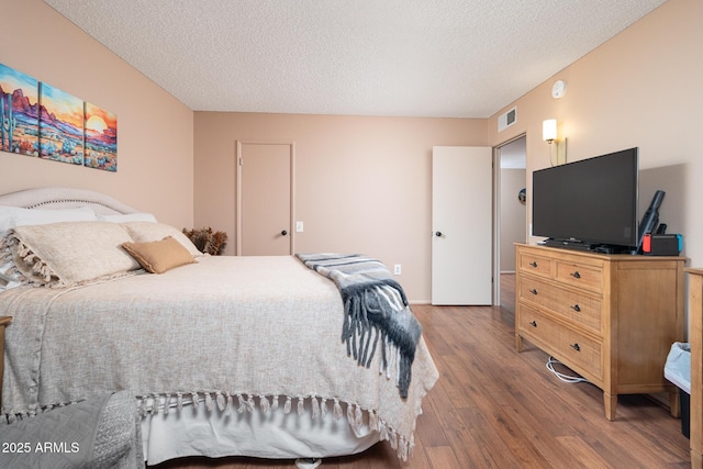 bedroom featuring hardwood / wood-style floors and a textured ceiling