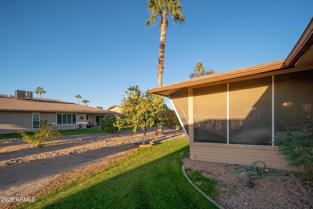 view of side of property featuring a yard and a sunroom