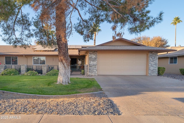 single story home with a front lawn, a garage, and solar panels