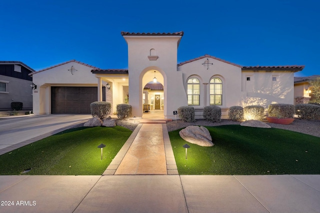 mediterranean / spanish-style house with a garage and a front yard