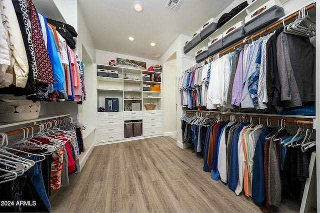 walk in closet with light hardwood / wood-style floors