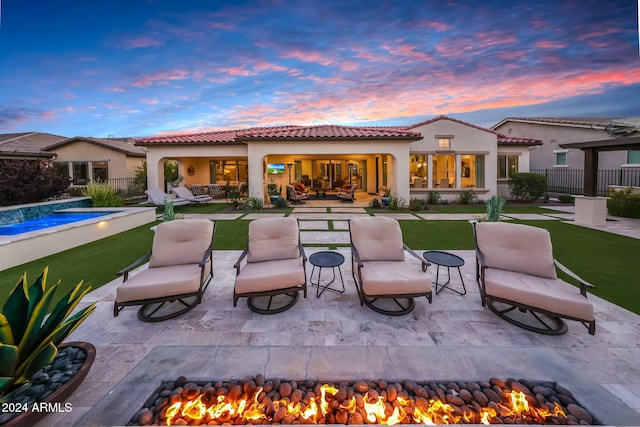 back house at dusk with a patio area