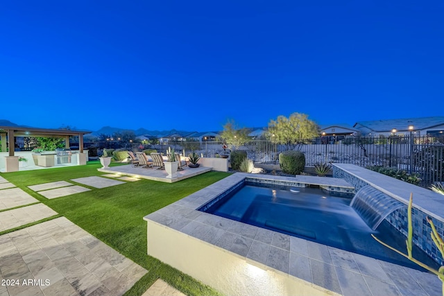 view of pool with a lawn, a patio area, an in ground hot tub, and exterior kitchen