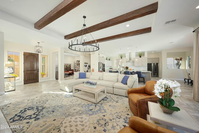 living room featuring beamed ceiling, plenty of natural light, and a chandelier