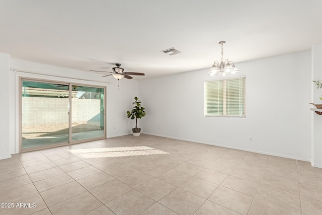 spare room with ceiling fan with notable chandelier and light tile patterned floors