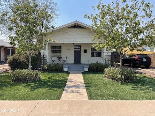 bungalow-style house featuring a front yard