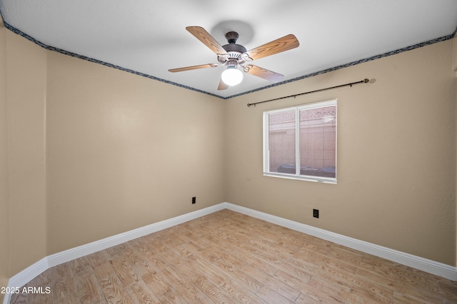 empty room with a ceiling fan, light wood-style flooring, and baseboards