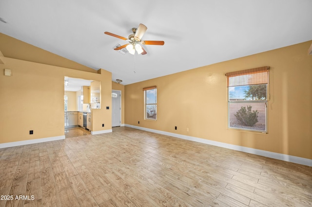 unfurnished living room featuring lofted ceiling, light wood-type flooring, and a healthy amount of sunlight