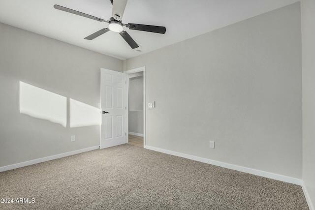 carpeted spare room with ceiling fan