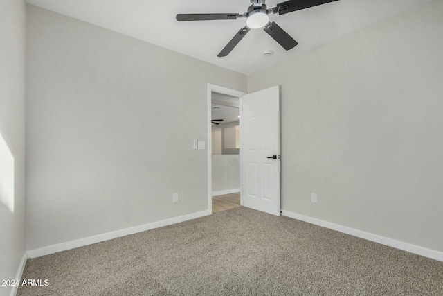 carpeted empty room featuring ceiling fan