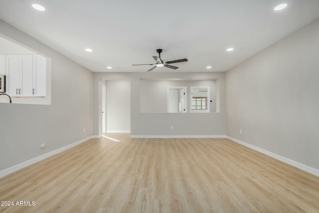 unfurnished living room featuring ceiling fan and light wood-type flooring