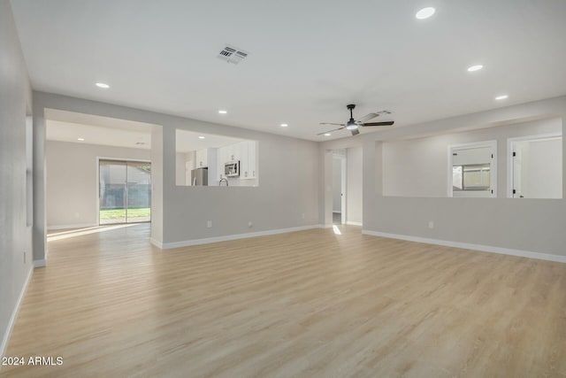 empty room with ceiling fan and light hardwood / wood-style flooring